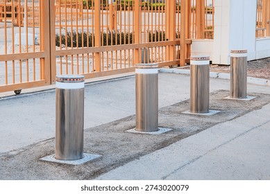 Row of modern automatic retractable bollards rising from asphalt, creating a barrier for access control and enhancing security at an entrance