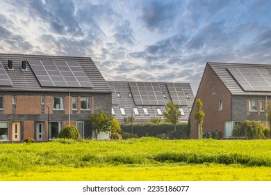 Row of modern family houses in contemporary street. New ecological neighborhood with solar panels. Small  gardens and private parking places. Street view in Heerhugowaard, Netherlands.