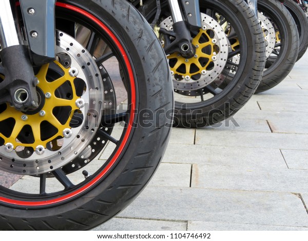 Row of motorcycles close-up. Wheels motorbikes in\
the parking lot, bike disc