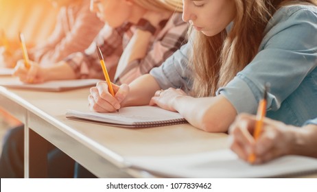 Row of Multi Ethnic Students in the Classroom Taking Exam/ Test/ Writing in Notebooks. Bright Young People Study at University. - Shutterstock ID 1077839462
