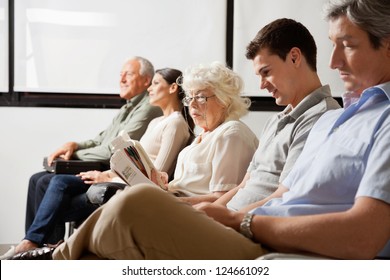 Row of multiethnic people waiting for the doctor in hospital lobby