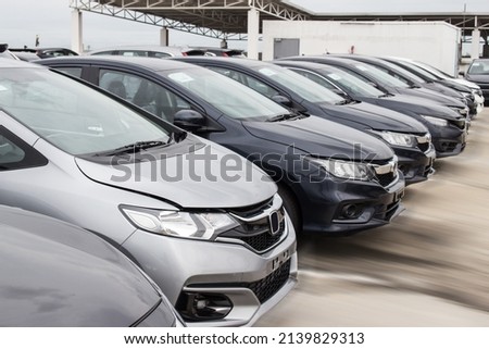 A row of new cars parked at a car dealership stock