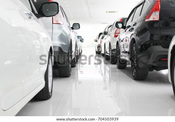 A row of new cars parked\
at a car dealership stock, New Japanese cars in showroom for show\
customers.