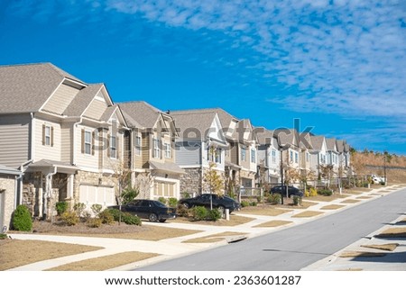 Row of new development two story houses with front garage driveway, well-trimmed landscape and large residential street suburbs of Atlanta, Georgia, USA, sunny blue cloud sky. Subdivision HOA area Foto stock © 