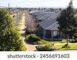 A row of new and modern residential suburban houses in a new developed estate in a Melbourne’s suburb. Many Australian homes on a straight street. Aintree, VIC Australia. Concept of growing population