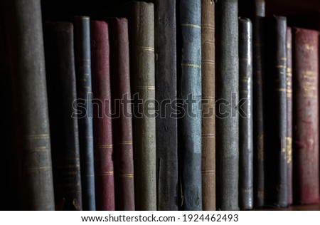 row of old books in the dark, without title