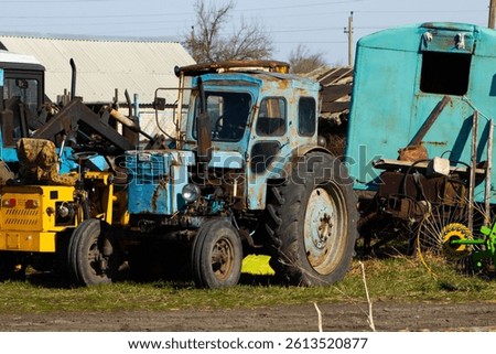 Row of Old and Dilapidated Tractor and Farm Equipment in a Yard