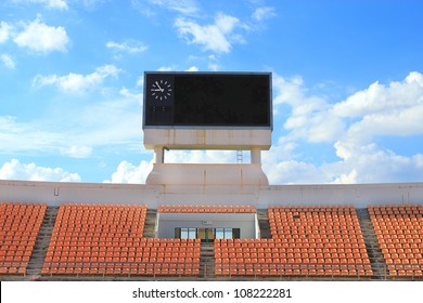 Row Of Orange Seats And Score Board In Stadium