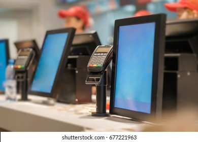 Row Of Order Desks With Computer Screen And Card Payment Terminal In Fast Food Restaurant