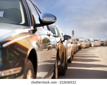 Row Of Parked Cars With Reflection Of Traffic And Buildings