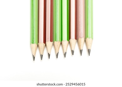 A row of pencils with green and brown stripes. Pencils lined up next to each other - Powered by Shutterstock