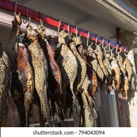 Row Of Pheasants Hanging On Hooks Outside A Butcher Shop UK