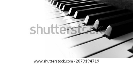 Row of piano keys fading into white panorama music