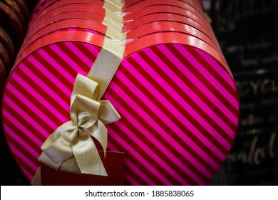 A Row Of Pink Striped Valentine Candy Boxes With Gold Ribbon In Store