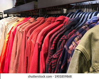 Row Of Plaid ,shirts Sorted In Color Order On Hangers On A Shop Wardrobe Closet Rail

