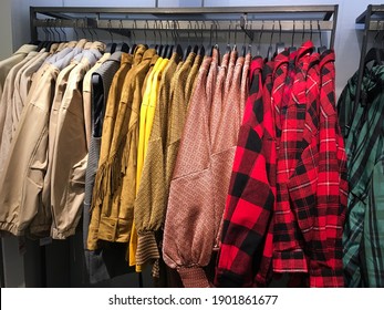 Row Of Plaid ,shirts Sorted In Color Order On Hangers On A Shop Wardrobe Closet Rail

