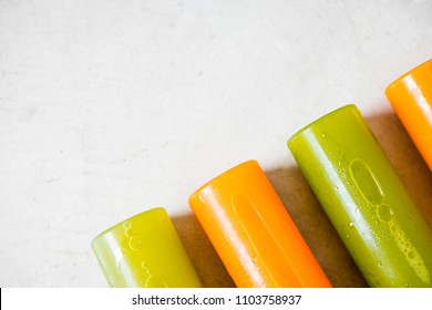 Row of plastic bottles of cold-pressed unprocessed fruit and vegetable juices, from above, light gray table. Body cleance, fast concept. Minimalism food photography. Copyspace