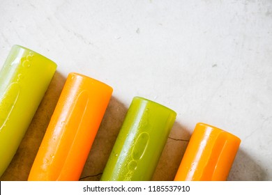 Row of plastic bottles of cold-pressed unprocessed fruit and vegetable juices, from above, light gray table. Body cleance, fast concept. Minimalism food photography. Copyspace