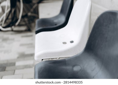 Row of plastic chairs at an empty stadium, creating a distinctive pattern. Concepts of emptiness, waiting, and abstract design