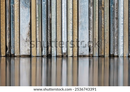Row of plates and components made of non-ferrous metals on reflective metal surface