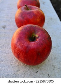 Row Of Red Apples On White Stone Background