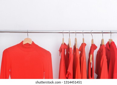 Row of red sweater, pink shirt with colorful clothes on a hanger - Shutterstock ID 1314451451