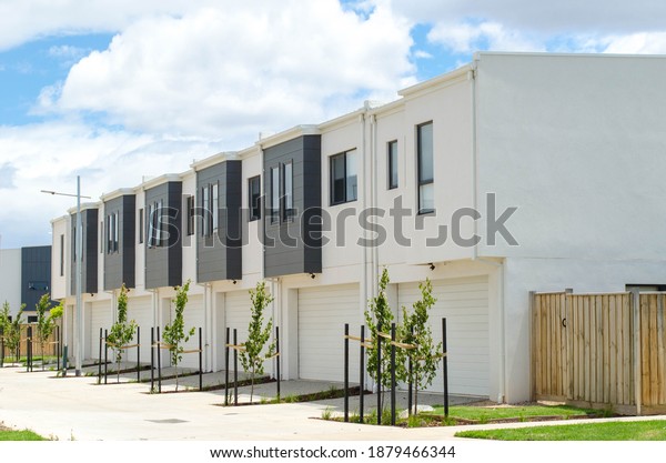 A row of residential townhomes\
or townhouses in Melbourne\'s suburb, VIC Australia. Concept of real\
estate development, the housing market, and\
homeownership.