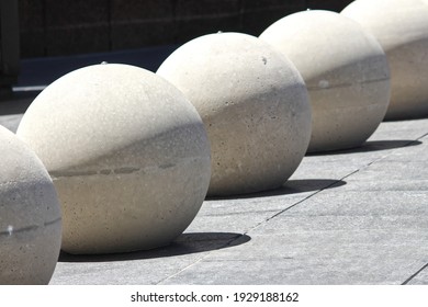 A row of round concrete bollards in the shape of a sphere. The bollards are in Martin place in Sydney's CBD