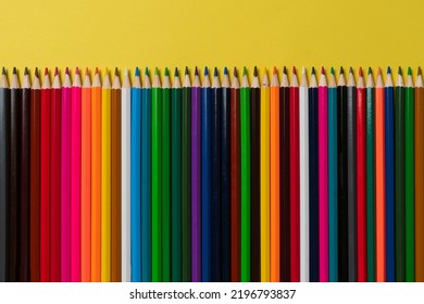 Row Of Set Of Colored Pencils Flat Lay On Pastel Background