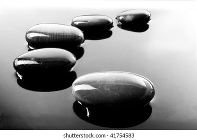 A Row Of Shiny Black Pebbles In Water