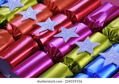 Row Of Shiny Festive Christmas Cracker Bon Bons In Bright Cheerful Red, Pink, Orange, Blue And Green Colors. Angle.