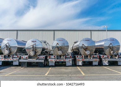 Row of shiny metal tanker trucks used to transport fuel. - Shutterstock ID 1042716493