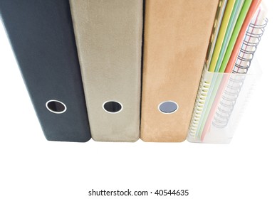 A Row Of Suede Lever Arch Ring Binders - Black, Tan And Faun And A Clear Plastic Magazine Rack Containing Cardboard Files In Blue; Green; Orange; Yellow; White Plus Spiral Bound Notebook.