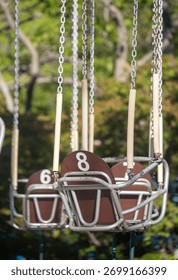 A row of swings with numbers 8, 6, and 7 on them. The swings are suspended from chains and are empty