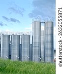 Row of tall silos are lined up in a field