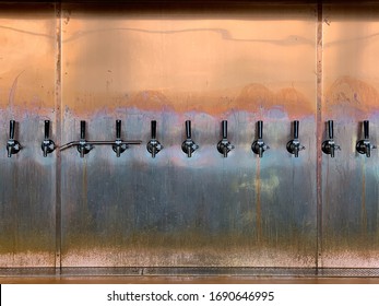 Row Of Taps Of Brewery Beer On Copper Sheet Wall Background