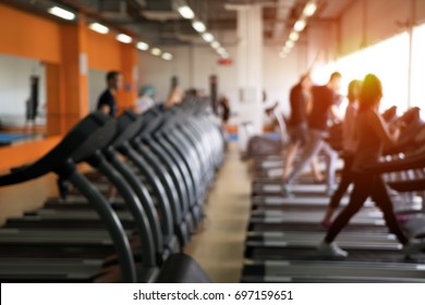 Row Of Treadmills In Modern Fitness Center. Blurred Picture Of Running People. Gym Equipment.