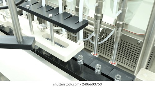 a row of vaccine making process injection vials filling with liquid medicine for injection production in a pharmaceutical injectable manufacturing company