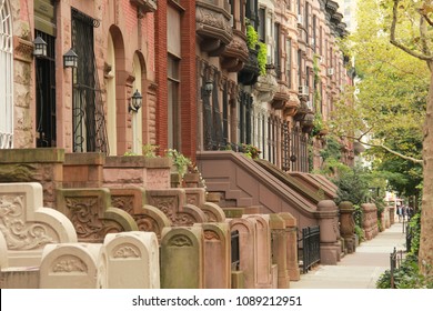 A row of various colored brownstones in uptown Manhattan, NYC - Shutterstock ID 1089212951