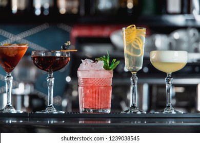 row of various colourfull alcoholic cocktails on a bar desk. Glasses of differen shapes