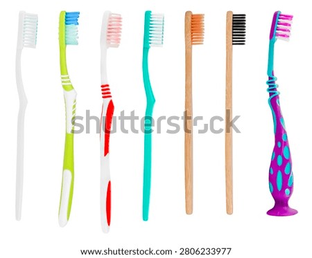 Row of various plastic and bamboo toothbrushes isolated on white background.
