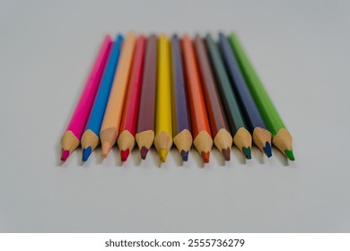 Row of vibrant colored pencils on a white background, symbolizing creativity, education, and artistic expression - Powered by Shutterstock