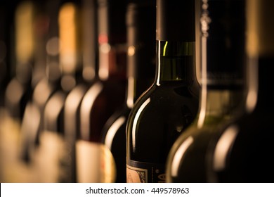 Row of vintage wine bottles in a wine cellar (shallow DOF; color toned image)