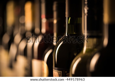 Row of vintage wine bottles in a wine cellar (shallow DOF; color toned image)
