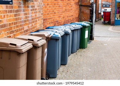 A Row Of Wheelie Bins Holding A Mix Of Household, Recycling And Garden Waste That Are Waiting To Be Collected By The Council Refuse Service