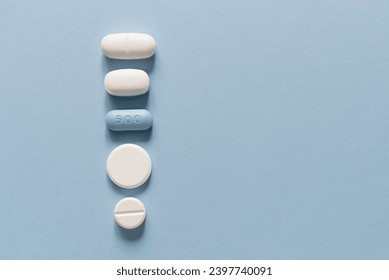Row of white and blue tablets of different sizes and shapes on a blue background. Mock up for special offers as advertising. Medical and healthcare concept. Empty copy space for text or logo