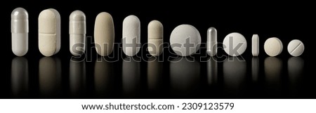 Row of white pill tablets and capsules. Concept for addiction, over medicated, or a variety of healthcare options.