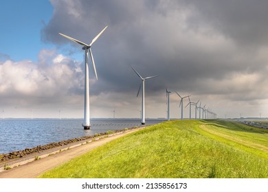 Row of Windturbines in lake along a Dike in the Netherlands