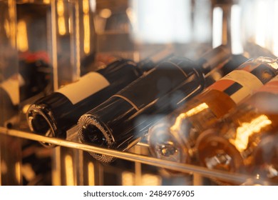 A row of wine bottles on a shelf, some of which are labeled with the word "champagne" - Powered by Shutterstock