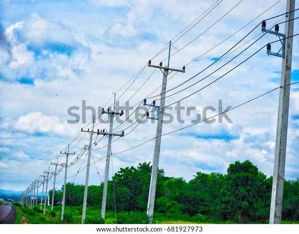 row of wire pole inside road on countryside with blue\
sky  \
